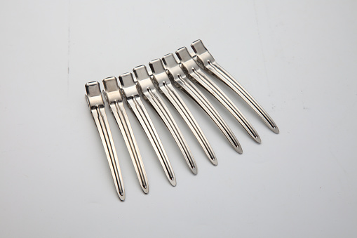 eight silver hair-pin in a row on plain background