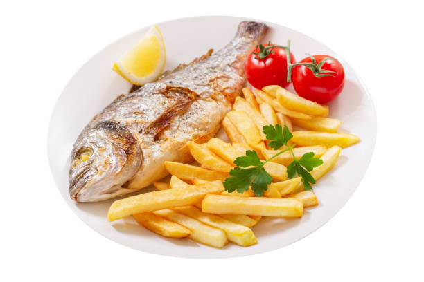 Plate of baked fish and french fries on white background stock photo
