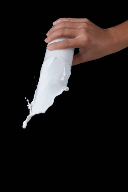 istock hand holding glass milk with the splash isolated on black background 1659171854