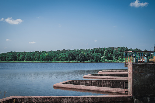 Landscape of the big dam, the Teteriv river, green forest and blue sky.
