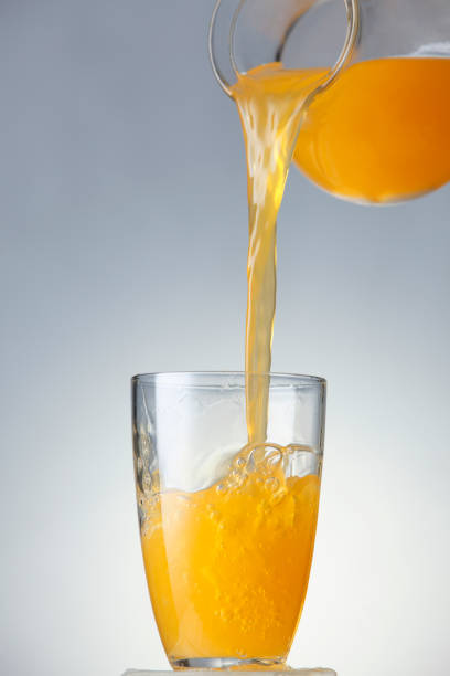 istock pouring orange juice from jug to glass 1659176363