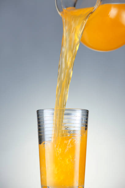 istock pouring orange juice from jug to glass 1659176416