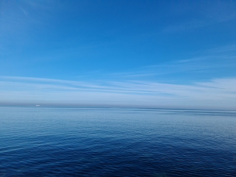 Tranquil beach scene with blue ocean, peaceful sky, and serene horizon over water.