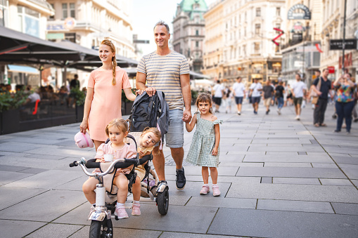 Happy family with three little daughters exploring the city of Vienna