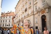 Blonde woman taking pictures with mobile phone while exploring the city of Vienna