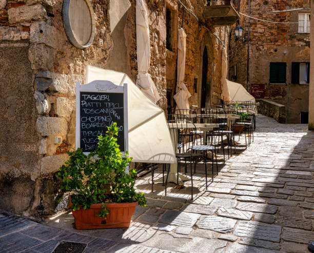 Empty tables and chairs of a trattoria, siesta time in an Italian town