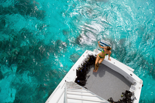 high angle view of a woman in bikini sitting at a boat getting ready for a diving excursion in the Caribbean