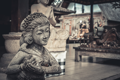 Traditional balinese stone sculpture of woman in Bali, Indonesia.