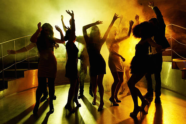 People grooving on the dance floor at a night club Silhouettes of group of people grooving on the dance floor at a night club dance floor stock pictures, royalty-free photos & images