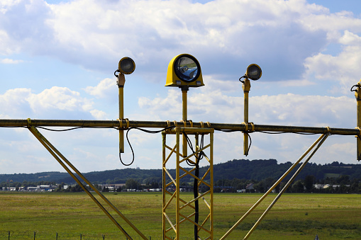 Signal poles in front of the runway, on the landing path. PAPI signaling lighting