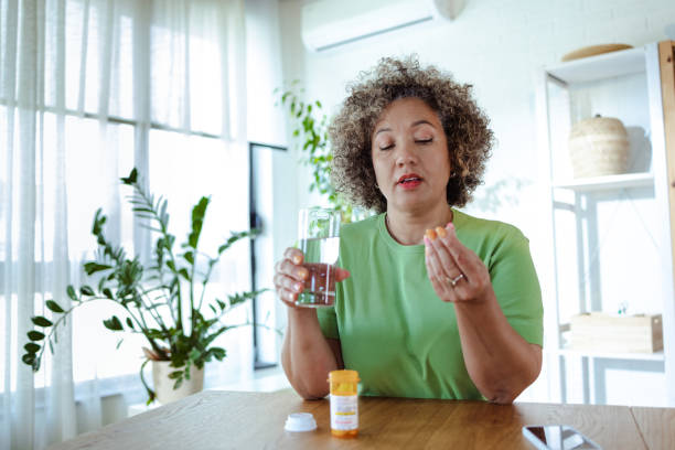 istock Mature woman taking medicines at home 1659304344