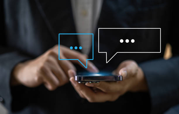 istock Human hand using smartphone typing Live chat chatting and social network concepts, chatting conversation working at home in chat box icons pop up. Social media marketing technology concept 1659312918