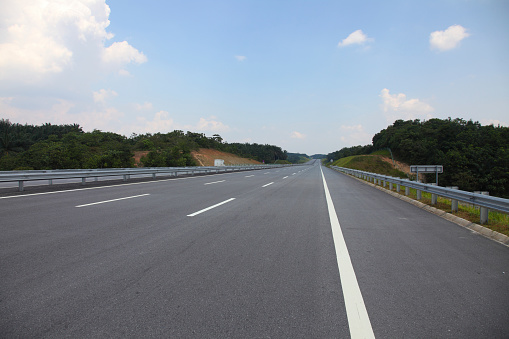 perspective  view of highway through green landscape