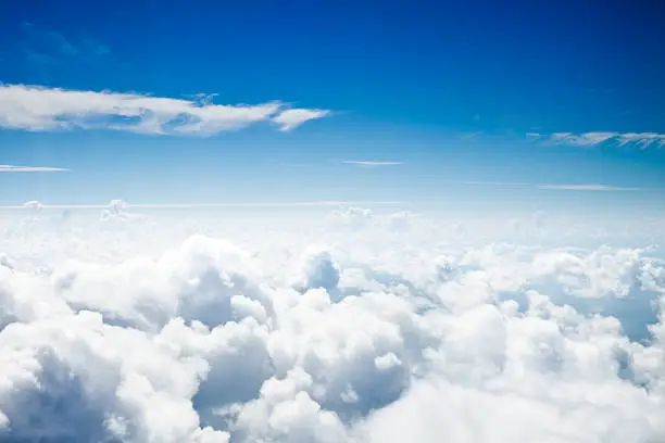 Cloudscape and stratosphere shot out of an airplane window. Some grain visible.