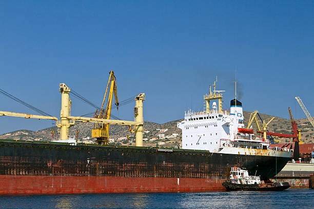istock Tugboat at work with a ship in a harbor 165932830