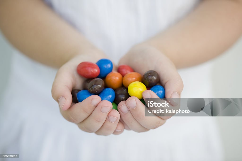 Zwei Hände, ein Kind holding bunten Süßigkeiten - Lizenzfrei Kind Stock-Foto