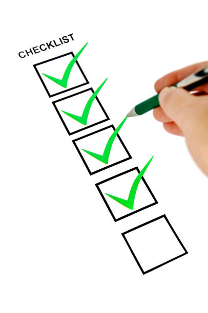 Green checklist with pen holding hand. stock photo