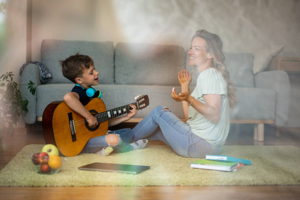 istock Boy playing guitar whit his mother 1659335486