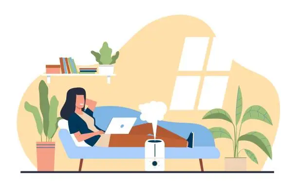 Vector illustration of Woman enjoys fresh moist air in her home thanks to an ultrasonic humidifier. Living room interior with plants, girl working on laptop on sofa. Cartoon flat style isolated vector concept