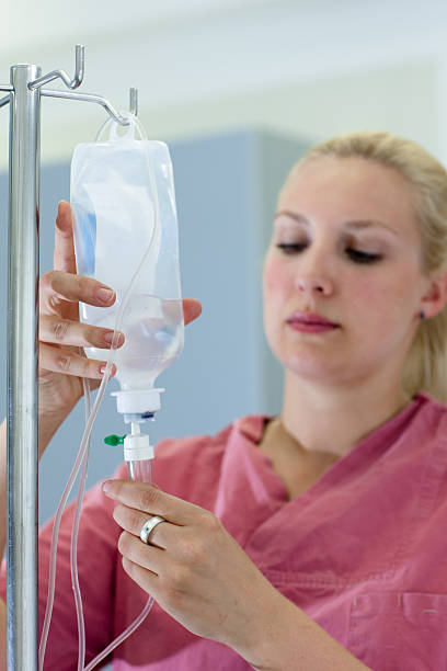 istock blond female nurse prepares an IV Drip 165934599