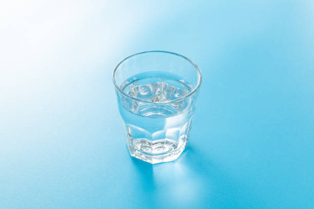 istock Glass of water on blue background. 1659347036