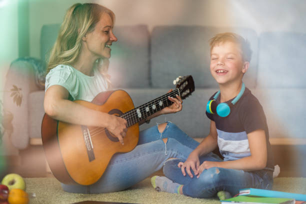 istock Happy woman playing guitar whit her son 1659347080