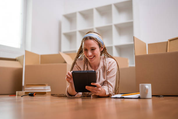 istock Happy ginger woman using digital tablet  in her new home 1659348756