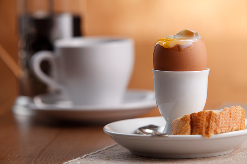 perfect soft-boiled egg, egg cup , spoon, and cup of coffee