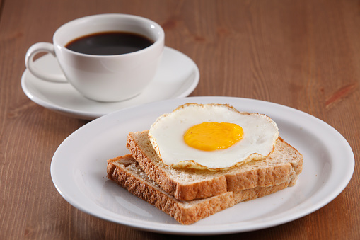 Fried Egg On The Bread On The White Dish and coffee