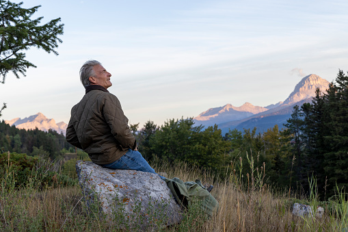 The sun illuminates the mountains in distance, Crowsnest Pass, Alberta