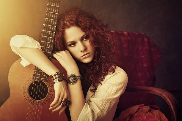 hippie girl embracing her acoustic guitar