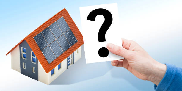 Doubts and uncertainties about photovoltaic system installation on a residential building - concept with home model stock photo