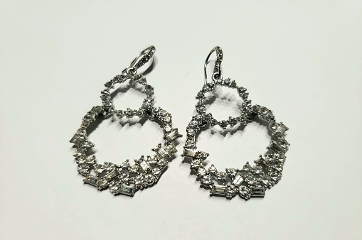This stock image features two sterling silver diamond-shaped earrings with dangling levers at the top
