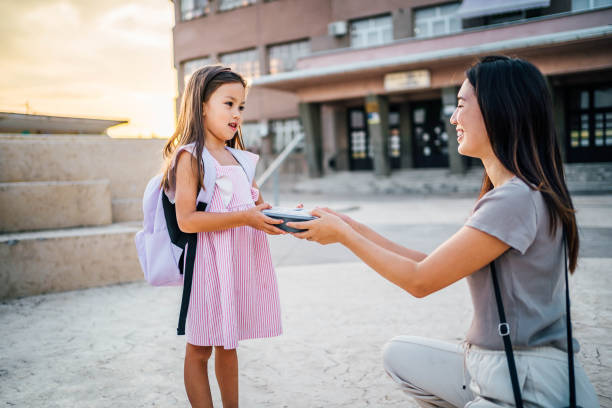 istock School girl taking lunch box from her mother 1659417696