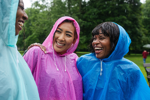 A close up of three women who are about to take part in a park run in Newcastle Upon Tyne. They are smiling and laughing as they wait for the race to start.