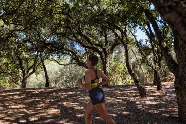 20 year old woman, generation Z, running in the park in crop top and shorts