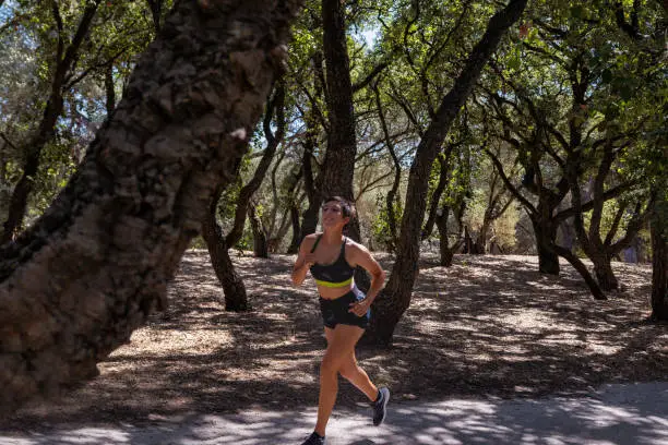 20 year old woman, generation Z, running in the park in crop top and shorts