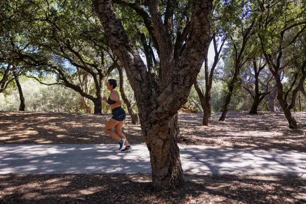 20 year old woman, generation Z, running in the park in crop top and shorts