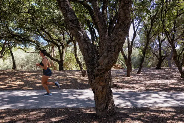 20 year old woman, generation Z, running in the park in crop top and shorts