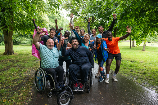 A close up front view of a group of race participants who have all taken part in a park run in Leazes Park in the North East of England. They are all looking into the camera with a  cheerful look on their faces. They agave just completed an inclusive race which was open to all ages and abilities.