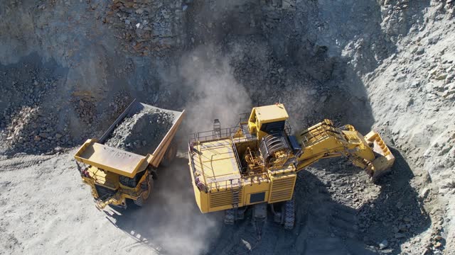 Quarry mining, work of the excavator on open mine pit, aerial slow motion shot