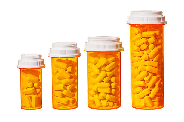 Rising Cost of Prescripton Drugs Bottles of pills arranged to represent a bar graph showing the rising cost of medicine and health care. medical diagram photos stock pictures, royalty-free photos & images