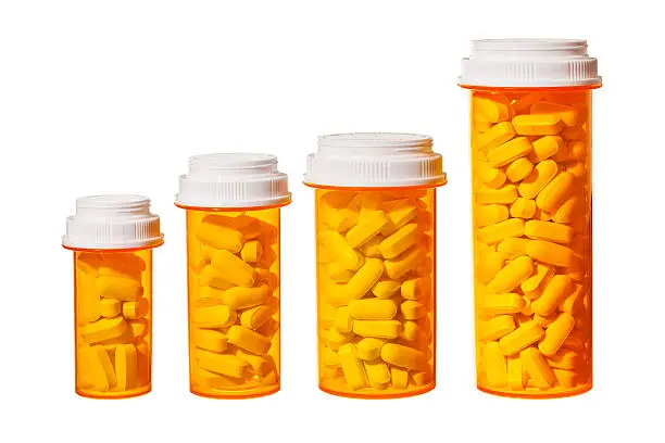 Bottles of pills arranged to represent a bar graph showing the rising cost of medicine and health care.