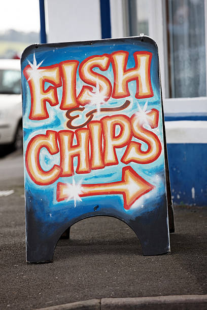 Fish and chips restaurant sign at state fair with white wood siding of building.