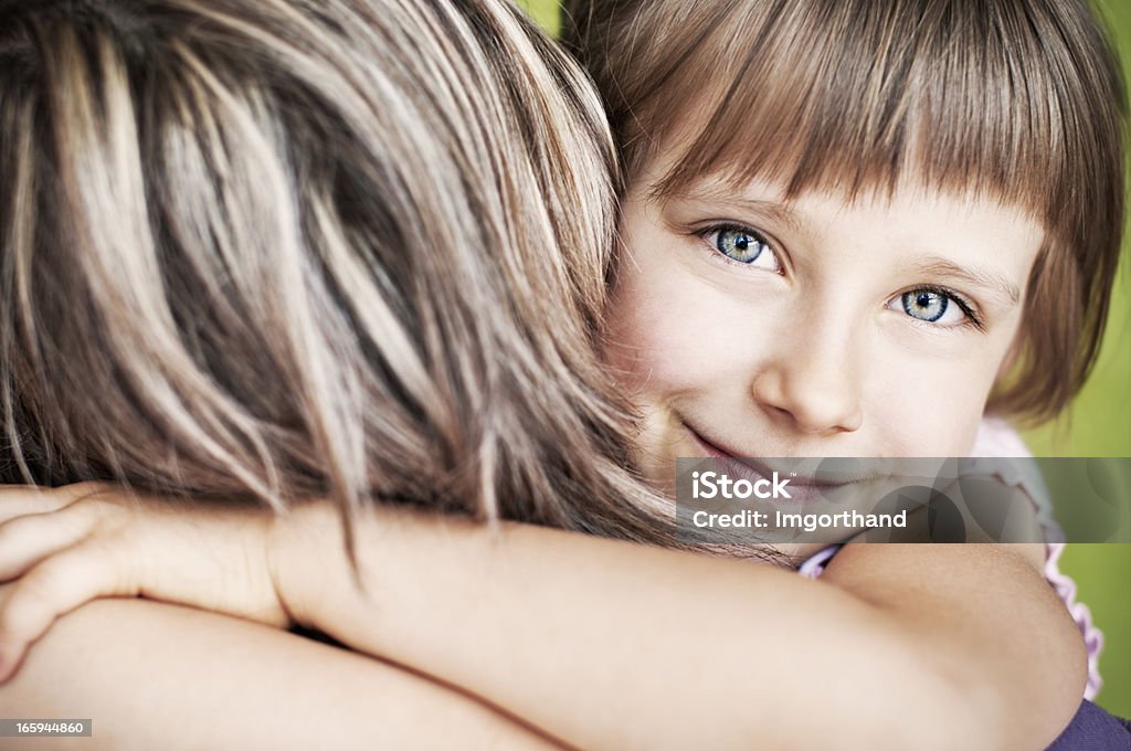 I love my mummy Portrait of a daughter hugging her mother. Very shallow depth of field, fine noise applied. Affectionate Stock Photo