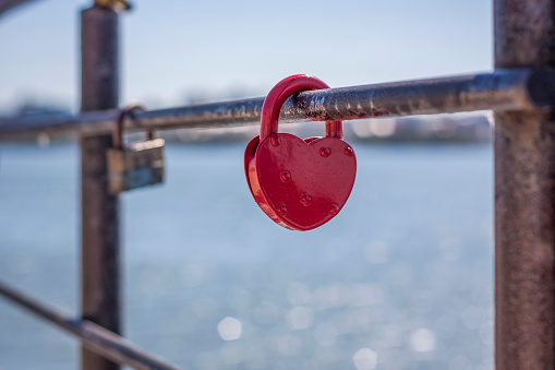 A heart-shaped door lock, a symbol of love and fidelity with a lake in the background, hangs on the fence of the bridge. The heart-shaped castle symbolizes loyalty and love.