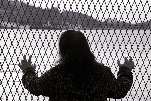 a woman standing in front of a fence
