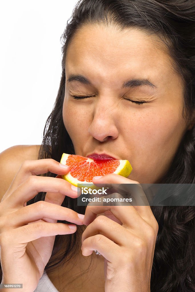 若い女性の顔をゆがめる顔をテイスティングサウアーグレープフルーツ - グレープフルーツのロイヤリティフリーストックフォト