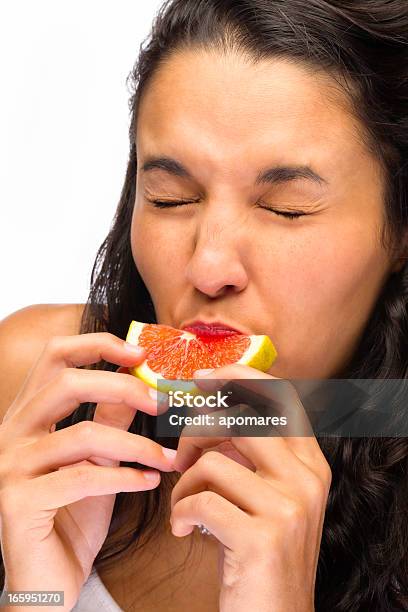 若い女性の顔をゆがめる顔をテイスティングサウアーグレープフルーツ - グレープフルーツのストックフォトや画像を多数ご用意 - グレープフルーツ, 酸っぱい, 食べる