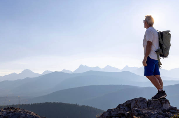 istock Mature male hiker arrives on mountain summit 1659546216